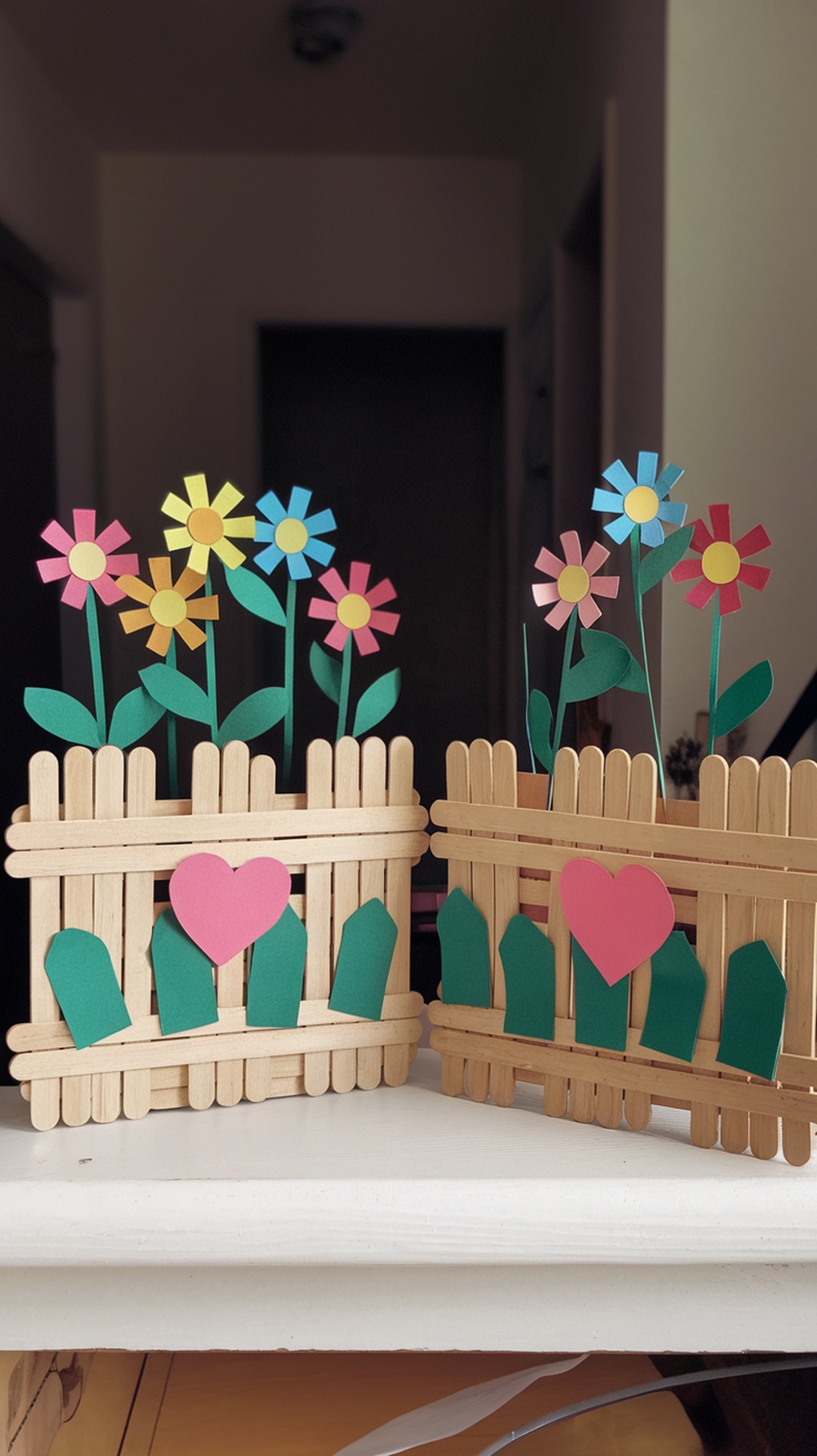 Colorful popsicle stick garden fence with flowers made from construction paper.
